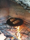 juicy cuts of meat are fried in a cast iron pan on burning coals in a barbecue oven