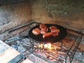 juicy cuts of meat are fried in a cast iron pan on burning coals in a barbecue oven