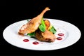 Juicy delicious cooked duck legs served with herbs and sauce in