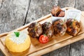 Juicy delicious meat cutlets and hominy or Corn porridge Polenta with goat cheese on cutting board on wooden background