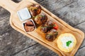 Juicy delicious meat cutlets and hominy ,Corn porridge Polenta, with goat cheese on cutting board on wooden background Royalty Free Stock Photo