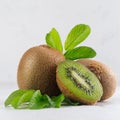 Juicy fresh kiwi with slice, leaves closeup on white wooden background, closeup, square. Royalty Free Stock Photo