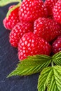 Juicy fresh natural raspberries on a dark stone background