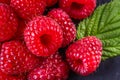 Juicy fresh natural raspberries on a dark stone background