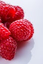 Juicy fresh natural raspberries on white acrylic background