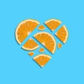 Juicy fresh orange slices forming heart shape on bright blue background. Minimal summer concept. Top view
