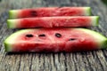 Juicy fresh red watermelon on the table. Watermelon sliced into pieces on a wooden texture background. Royalty Free Stock Photo