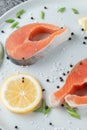 Juicy fresh salmon steak in a white plate with onion lemon and spices on a natural slate stone table Royalty Free Stock Photo