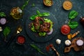 Juicy fried pork steak with spices on a black stone plate. Royalty Free Stock Photo