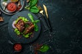 Juicy fried pork steak with spices on a black stone plate. Royalty Free Stock Photo