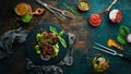 Juicy fried pork steak with spices on a black stone plate. Royalty Free Stock Photo