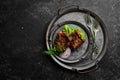 Juicy fried pork steak with spices on a black stone plate. Royalty Free Stock Photo
