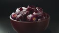 Juicy fruits of Mazafati dates in a wooden cup on a dark background rotate.