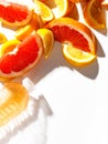 Juicy grapefruit slices and a bottle with juice on a white background. Top view Royalty Free Stock Photo