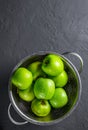 Juicy green apple in stainless steel colander on Dark grey black slate background Royalty Free Stock Photo