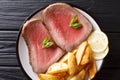 Juicy grilled beef steak with roasted potatoes and lemon close-up on a plate. Horizontal top view Royalty Free Stock Photo