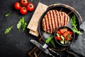 Juicy grilled chicken meat lula kebab on skewers with fresh vegetable salad on black background Royalty Free Stock Photo