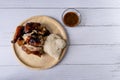 Juicy grilled chicken wing on wood plate and spicy Thai style sauce on white wood background. Thai food Royalty Free Stock Photo