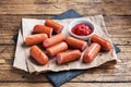 Juicy grilled half meat sausages with tomato sauce and ketchup on a wooden background. Fat fast food. Concept unhealthy