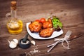 Juicy grilled pork fillet served with cherry tomatoes branch and lettuce on white plate. Background: wooden boards. Close-up. Royalty Free Stock Photo