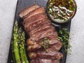 Juicy, grilled, sliced beef steak, with roasted asparagus, close up, sauce olive oil herbs and spices Royalty Free Stock Photo