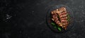 Juicy grilled steak from Angus with spices and herbs on a black background. Bull Angus. Top view. Rustic style Royalty Free Stock Photo