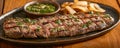 Juicy Grilled Steak Served with Chimichurri Sauce and French Fries on Wooden Table