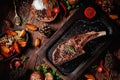 Juicy grilled steak T-Bone decorated rosemary on dark board on dark wooden background Royalty Free Stock Photo