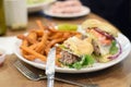 Juicy half eaten cheeseburger on plate Royalty Free Stock Photo