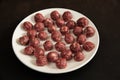 Juicy homemade beef meatballs on a white plate are close-up ready to cook on a dark background Royalty Free Stock Photo