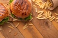 Juicy homemade french fries burgers. Wooden texture with space for design. Delicious and fast food