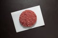 Juicy homemade hamburger, close-up. Raw minced meat on a dark textured background, top view Royalty Free Stock Photo
