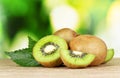 Juicy kiwi fruit on wooden table on green Royalty Free Stock Photo