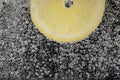 Juicy lemon slice in soda water against black background, closeup. Space for text Royalty Free Stock Photo