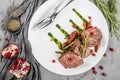 Juicy medium beef fillet steaks mignon with green beans, pomegranate and sauce in plate on grey background. Hot Meat Dishes, top