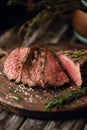 Juicy medium Beef Rib Eye steak slices on wooden board with herbs spices and salt