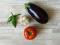 Juicy organic green peppers, red tomato, purple eggplant and white garlic top view  photo. Summer vegetables. Royalty Free Stock Photo