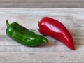 Juicy organic vivid green and ripe red peppers on bleached oak wood background. Two peppers. Summer autumn vegetables for salad. Royalty Free Stock Photo