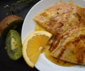 Juicy pancakes with fruits and orange sauce Royalty Free Stock Photo