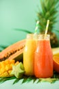Juicy papaya and pineapple, mango, orange fruit smoothie in two jars on turquoise background. Detox, summer diet food Royalty Free Stock Photo