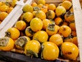 Juicy persimmons lie on the counter in a fruit store Royalty Free Stock Photo