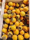 Juicy persimmons lie on the counter in a fruit store Royalty Free Stock Photo