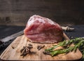 Juicy piece of fresh raw pork steak on vintage cutting board with herbs and spices wooden rustic background close up Royalty Free Stock Photo