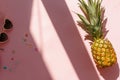 Juicy pineapple and pink sunglasses on trendy pink paper backgro