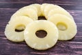 Yellow juicy pineapple rings. Caramelized canned pineapple. Raw food diet. Close-up plan. Woody background. Royalty Free Stock Photo