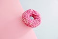 Juicy Pink Sprinkled Donut isolated on a Pink and Blue Background