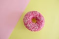 Juicy Pink Sprinkled Donut isolated on a Pink and Yellow Background