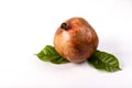 Juicy pomegranate fruit with leaves on the table on a white background