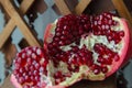 Juicy pomegranate fruit on a wooden suport.