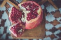 Juicy pomegranate fruit on a wooden suport.